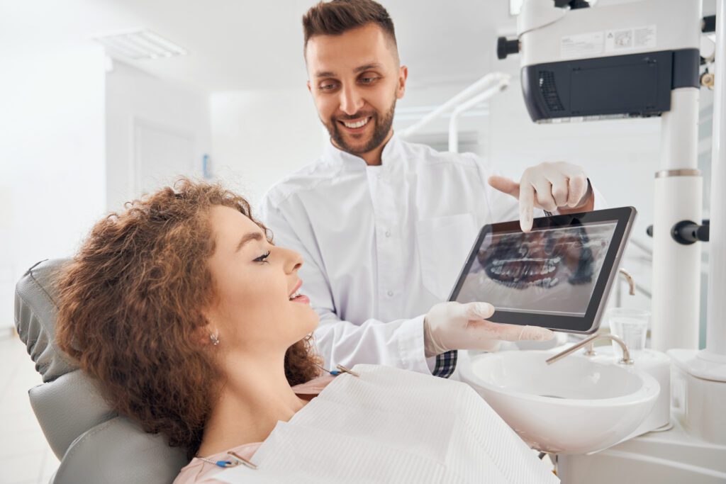Dentist reviewing dental X-rays with a patient while explaining implant costs at a Toronto clinic