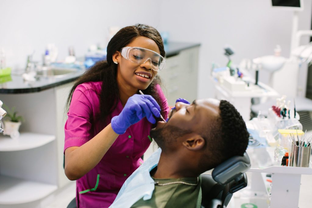 Dentist examining a patient's teeth during a routine dental exam